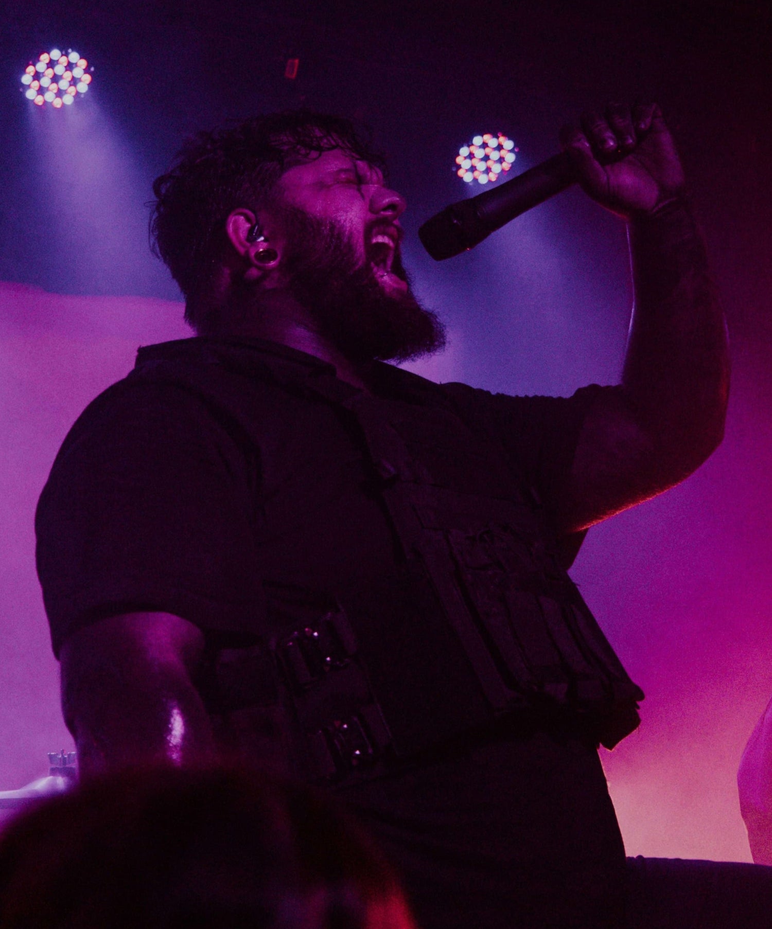 Storm Ruby singing into a microphone on stage with purple and pink lighting